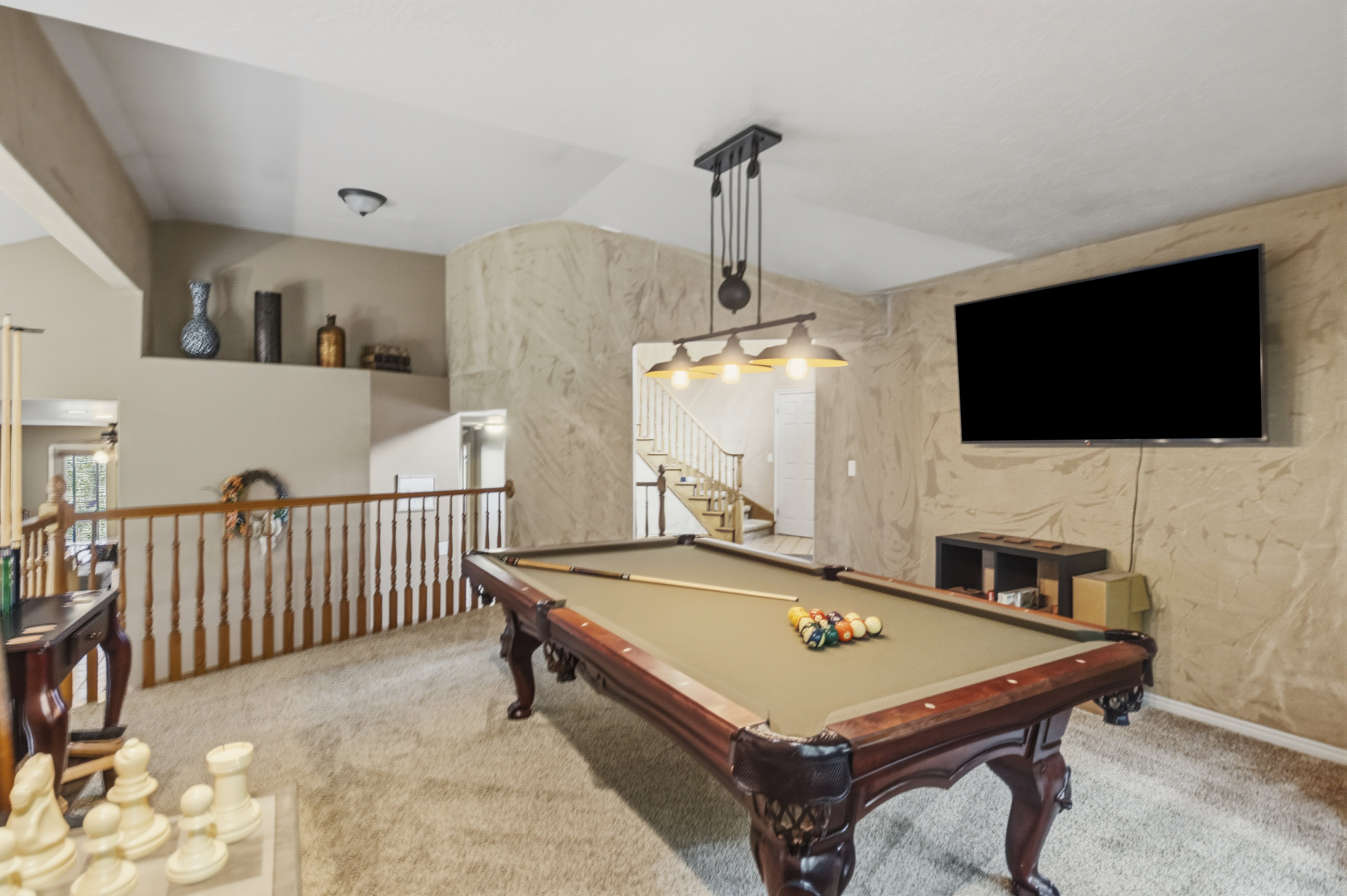 Carpeted loft area featuring a billiard table with a dedicated overhead light fixture