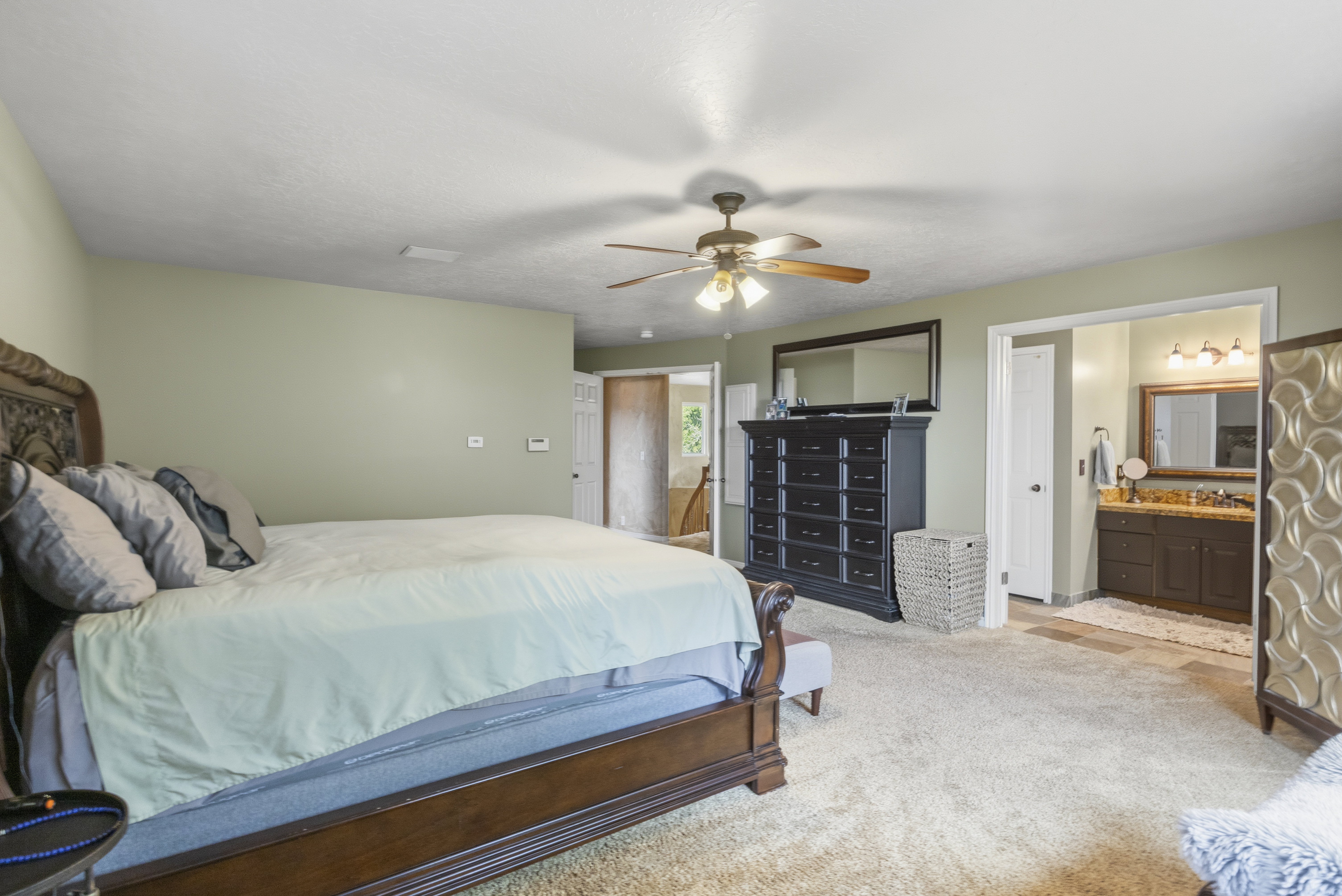 Bedroom featuring light green walls and plush carpeting