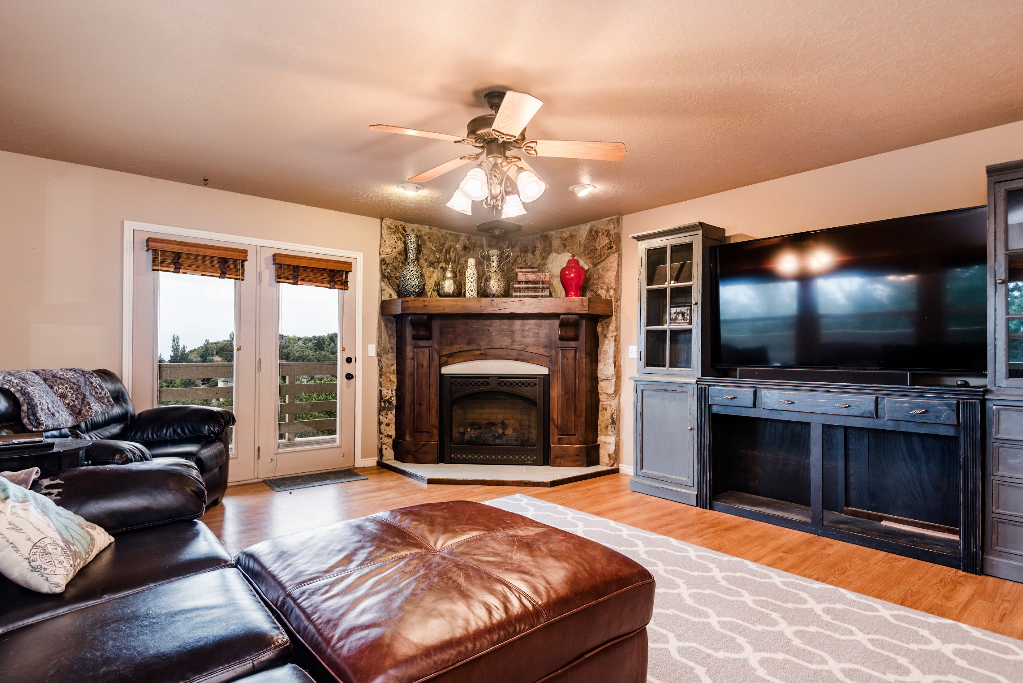 Corner fireplace with stone surround and wood mantel