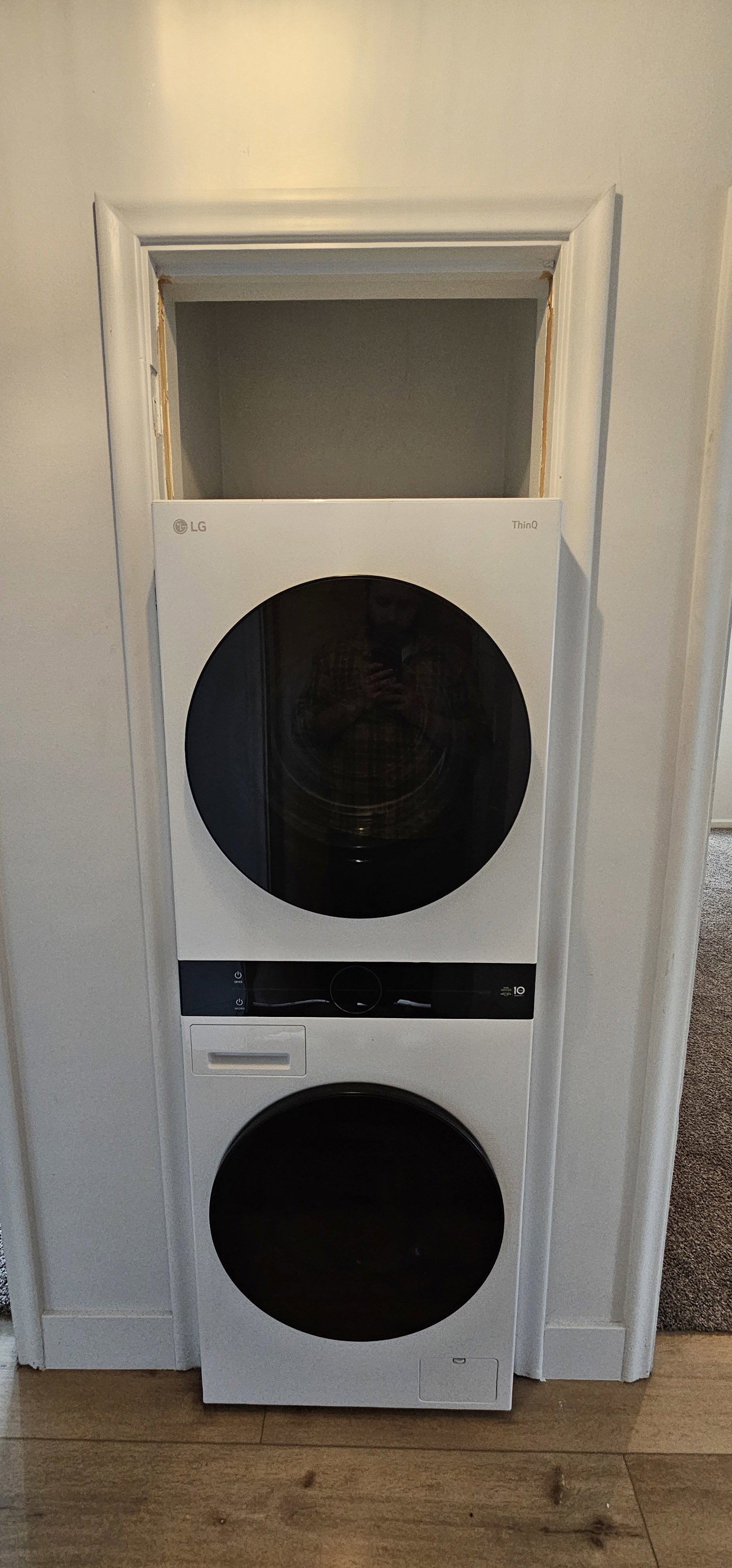 White stacked washer and dryer unit with black accents