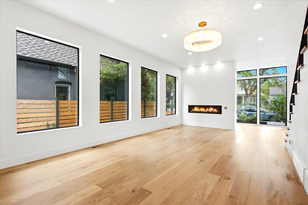 Spacious room with light wood-finish flooring, a linear fireplace, and recessed lighting
