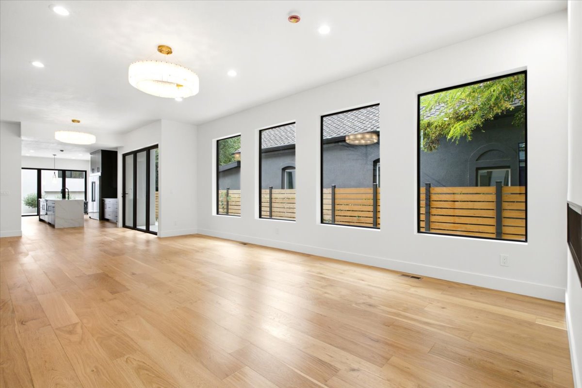 Spacious open-concept interior featuring light wood-finish flooring and recessed lighting