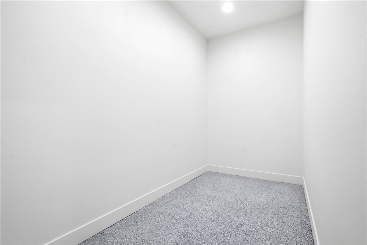 Compact interior space featuring white walls and a speckled gray floor
