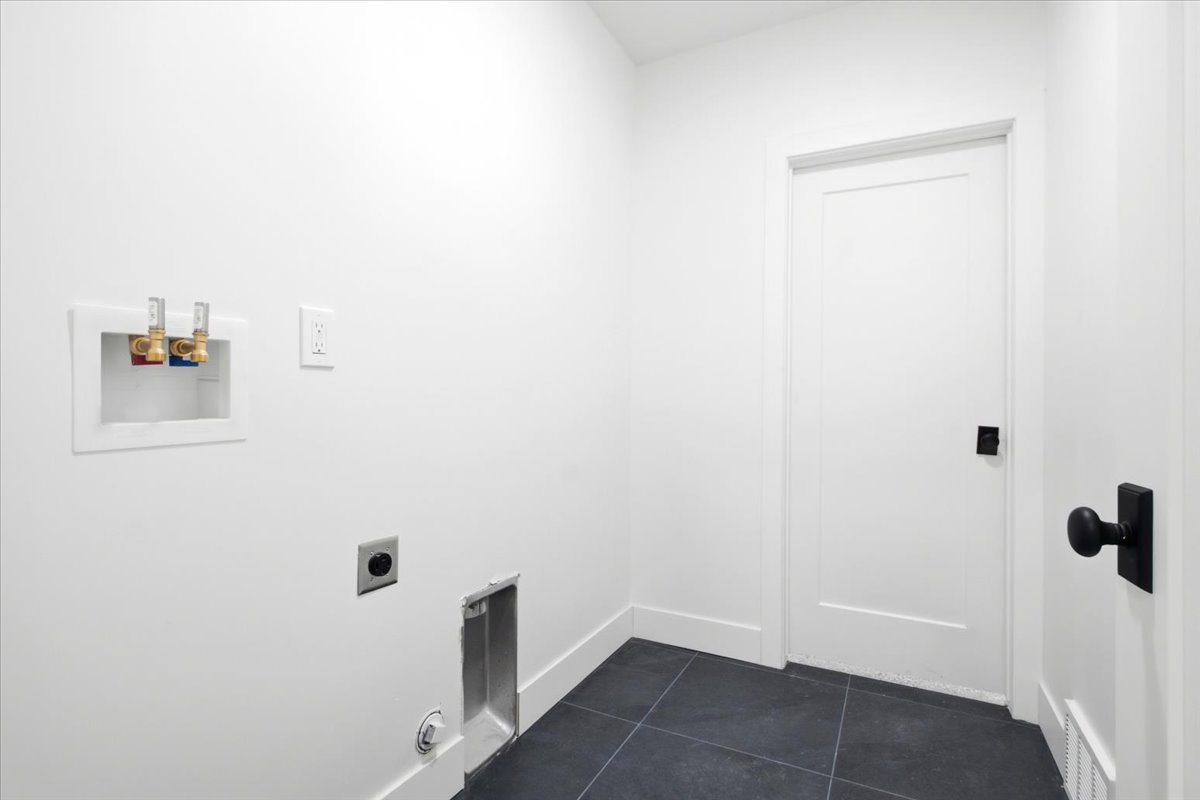 Laundry area with dark tile flooring