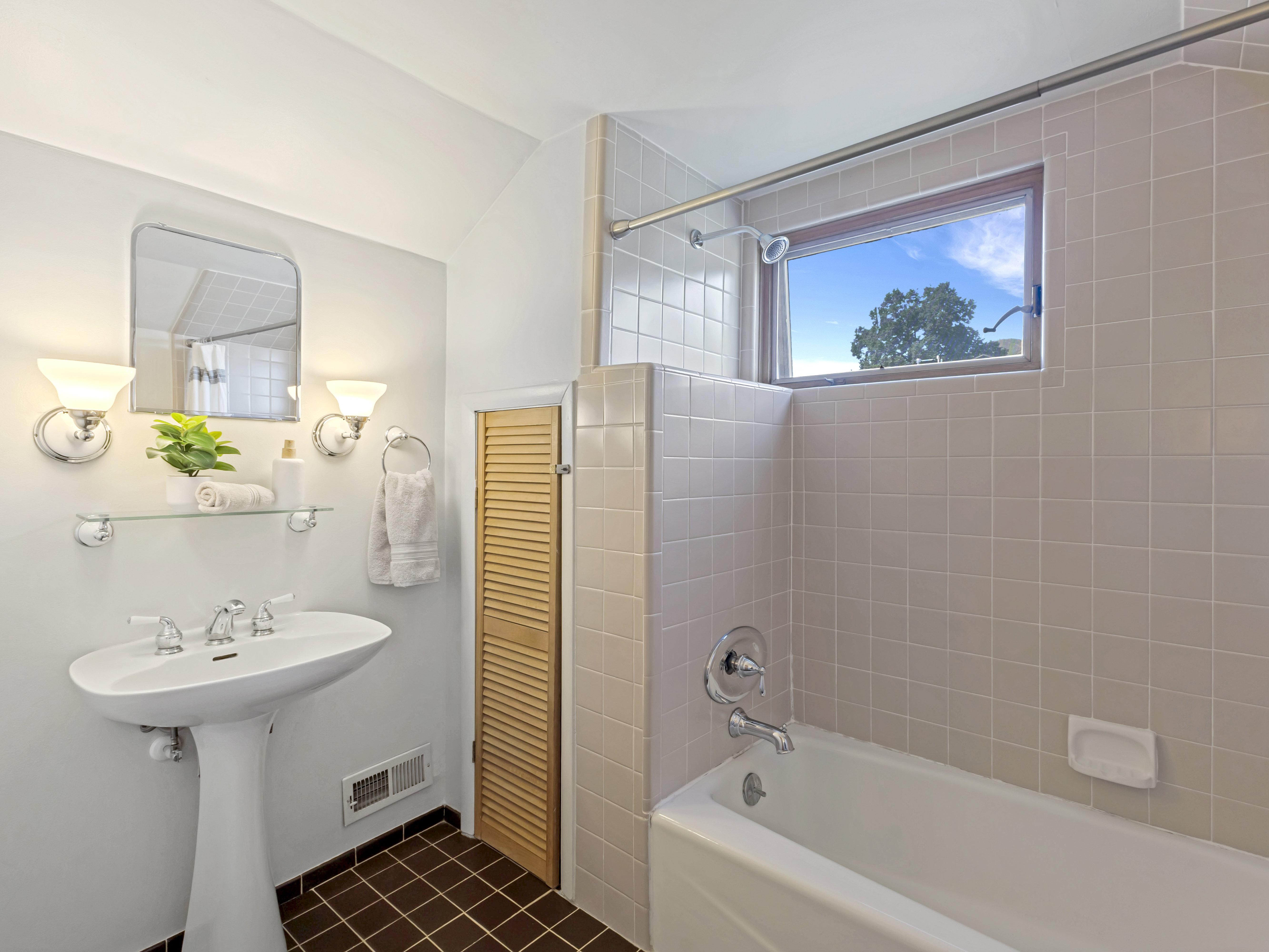 Full bathroom featuring a white pedestal sink, chrome fixtures, and a bathtub with a shower