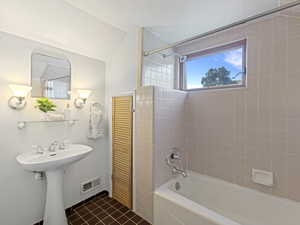 Full bathroom featuring a white pedestal sink, chrome fixtures, and a bathtub with a shower
