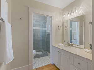 Vanity with white cabinetry and light-toned countertop, featuring a single basin and chrome fixtures