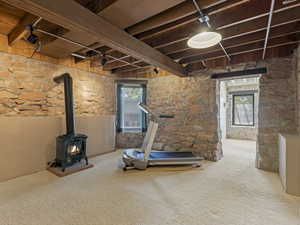 Exposed wood beam ceiling with track lighting and recessed fixture, complemented by stone wall finishes