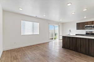 Open-concept living space featuring wood-finish flooring and recessed lighting