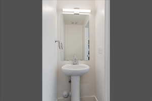 Pedestal sink with chrome-finish faucet and towel ring