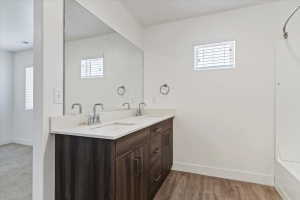 Double vanity with light-toned countertop, dual sinks, and chrome faucets