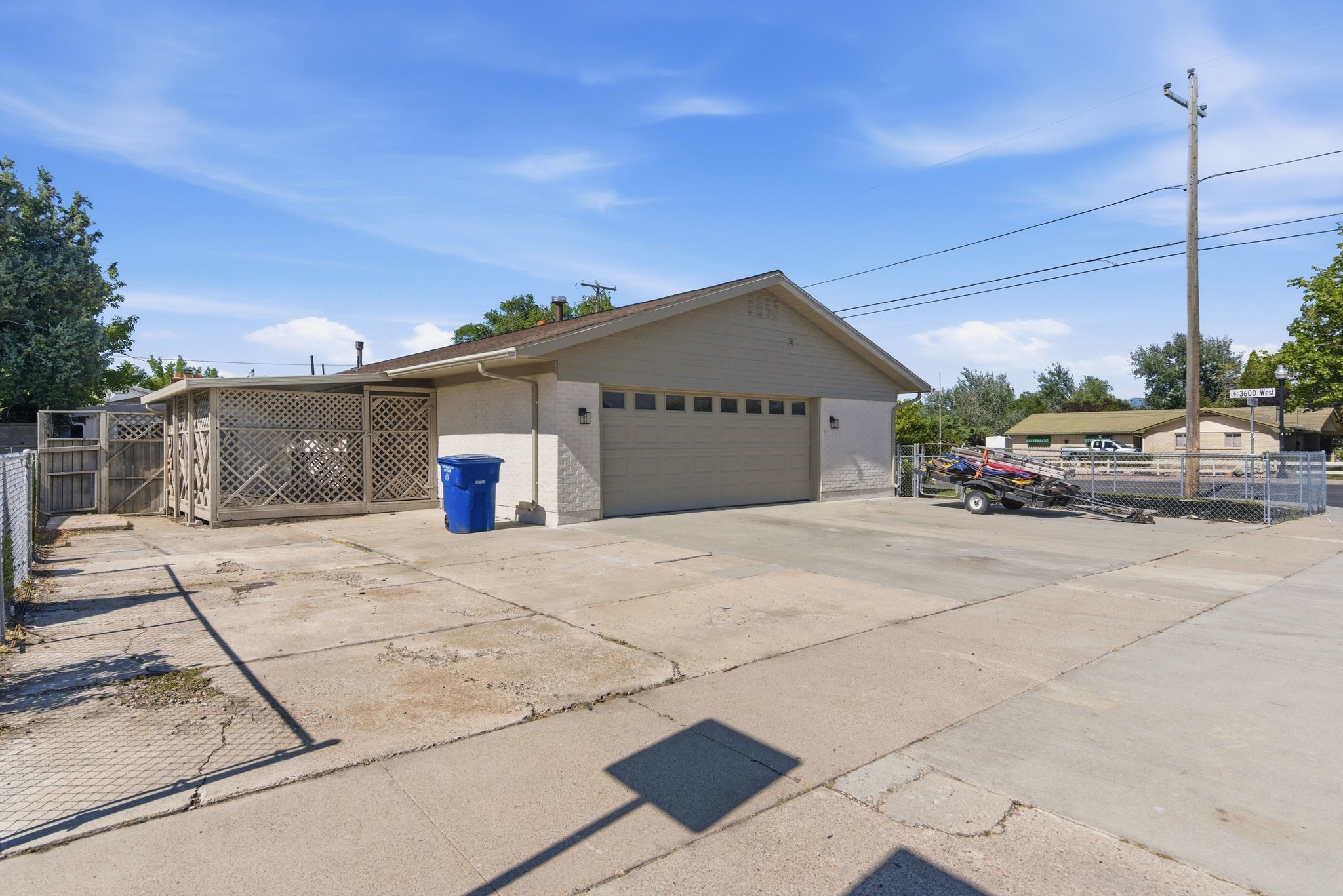 Expansive concrete driveway and two-car garage with a panel door