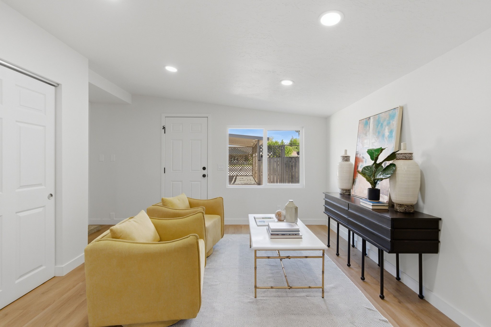 Bright interior space featuring recessed lighting, wood-finish flooring, white walls, and a large window overlooking the exterior
