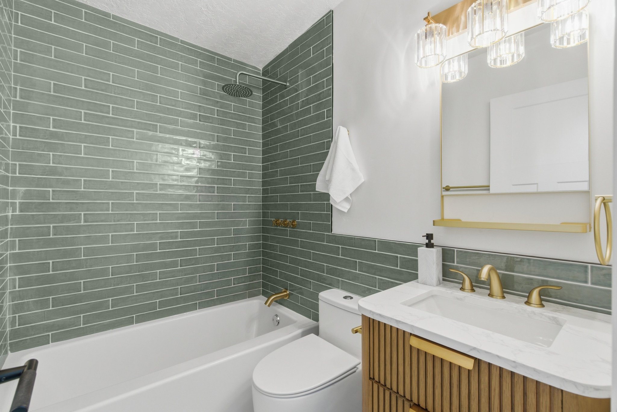 Bathroom featuring a white soaking tub, green subway tile shower surround, and a rain shower head