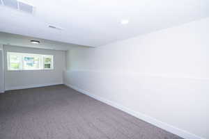 Bright room featuring a three-panel window, light-colored walls, and gray carpet flooring
