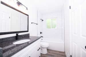 Contemporary bathroom featuring a white vanity with a dark speckled countertop and undermount sink