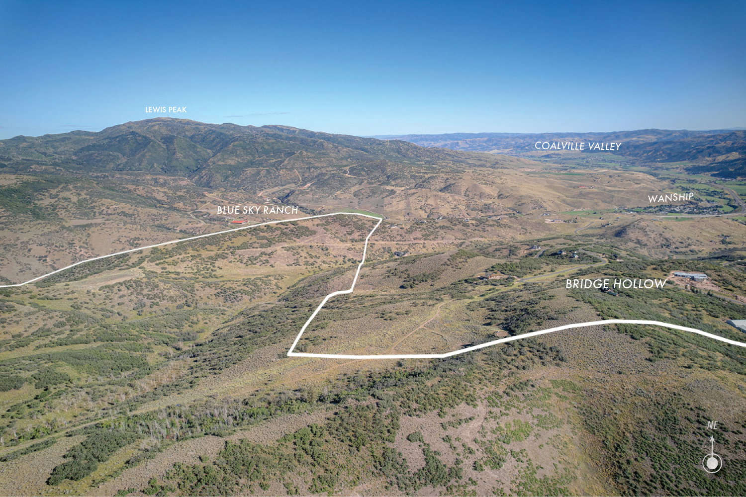 Expansive mountainous landscape with a clear blue sky overhead
