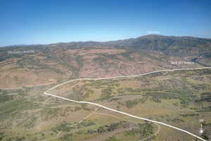 Expansive undeveloped land featuring a prominent mountain backdrop, natural topography, and clear skies