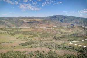 Expansive mountain property featuring varied topography, natural vegetation, and distant mountain ranges under a clear sky