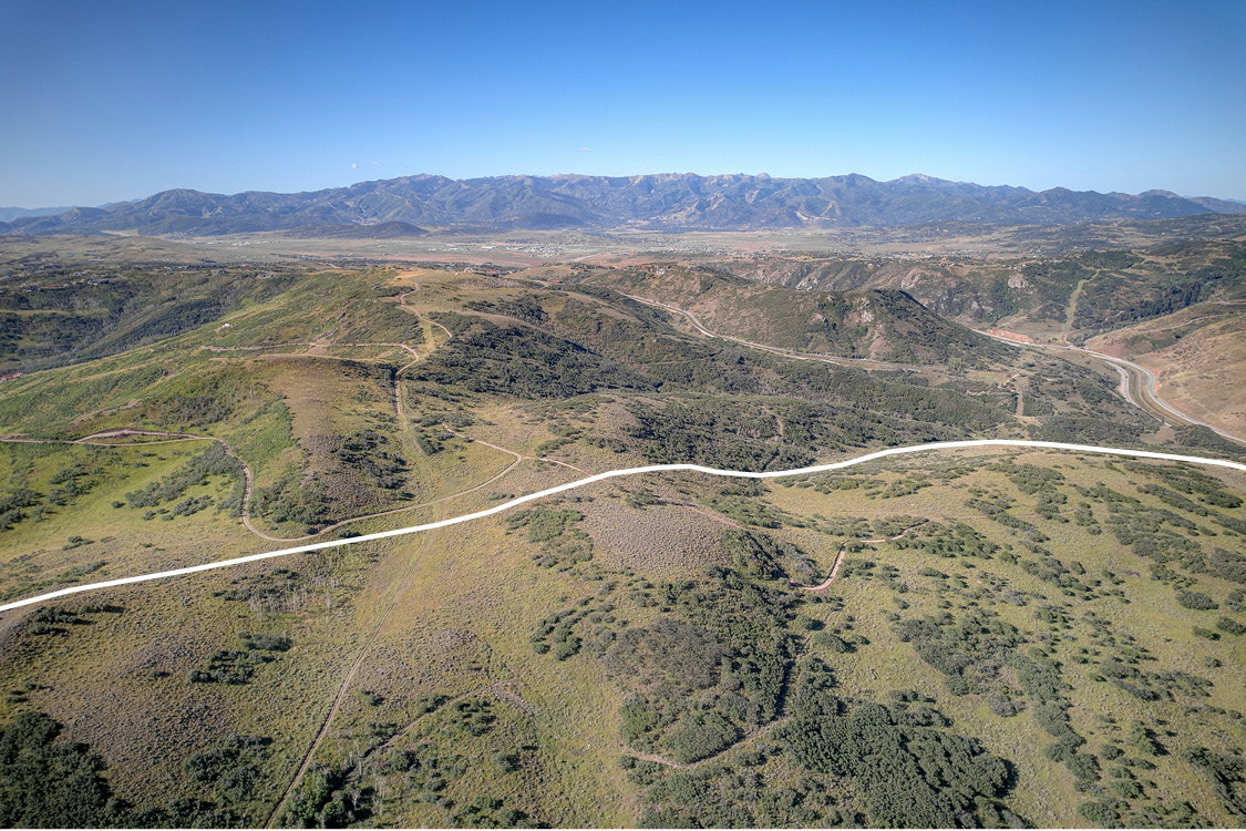 Expansive undeveloped terrain with distant mountain ranges under a clear sky