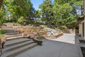Tiered landscaping with natural stone retaining walls and mature trees