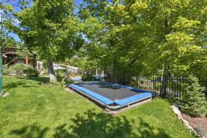 Expansive green lawn featuring mature trees providing ample shade