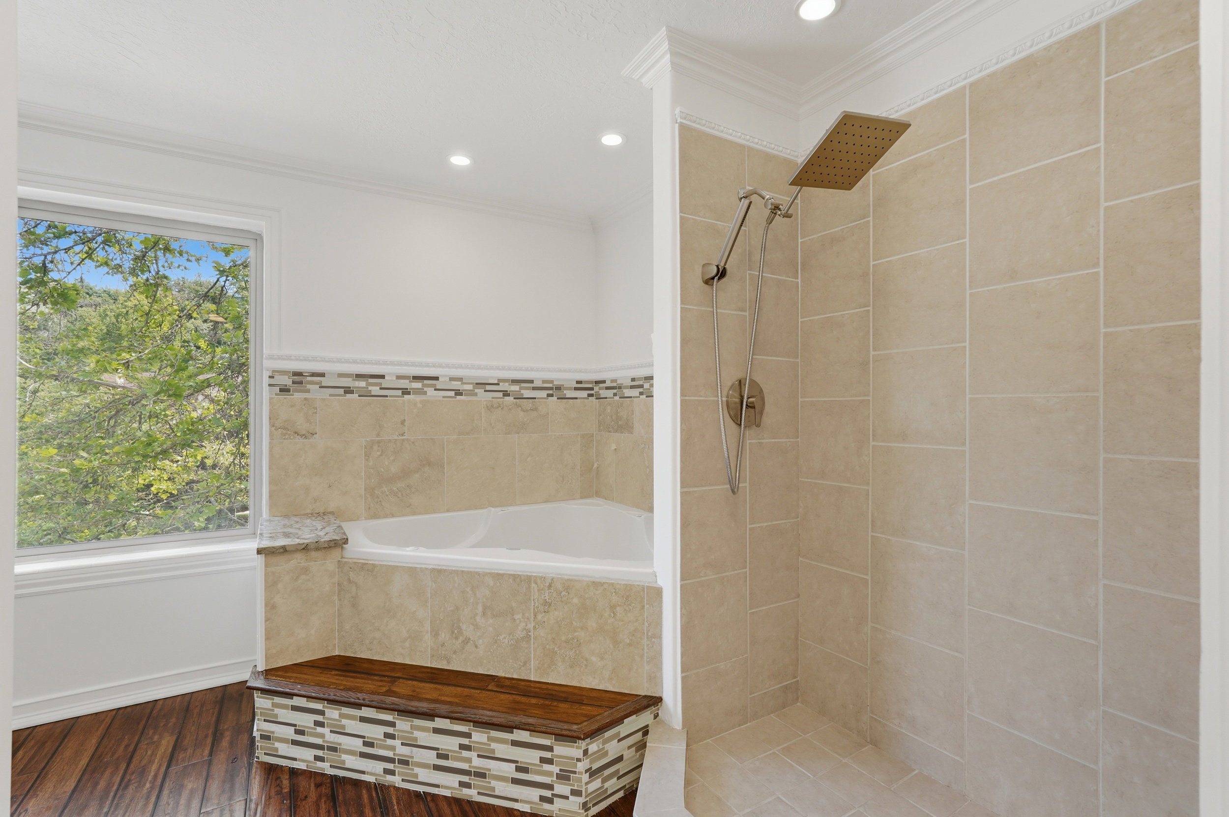 Shower stall with light-toned rectangular wall tile and a rain shower head