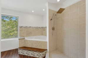 Shower stall with light-toned rectangular wall tile and a rain shower head