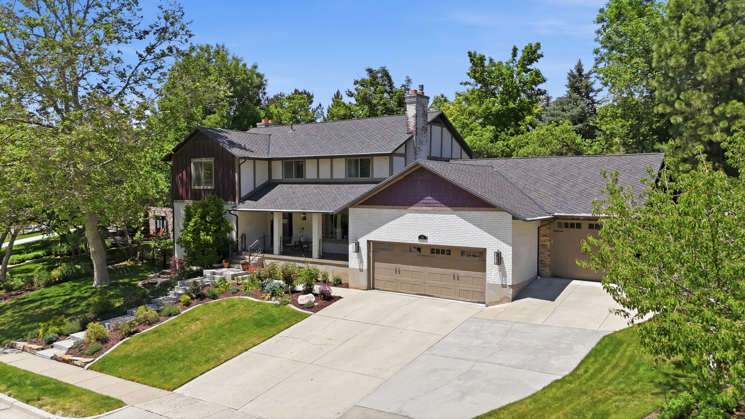 Expansive property featuring a multi-level architectural style, a covered front porch, and a paved driveway