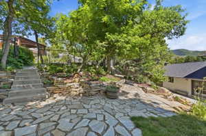 Expansive flagstone patio with concrete stairs and natural stone retaining walls