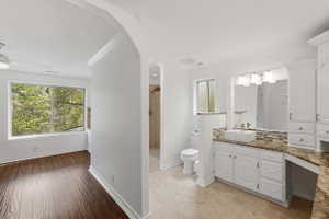Spacious bathroom featuring a vessel sink, an expansive vanity with storage, a large mirror, and tiled flooring