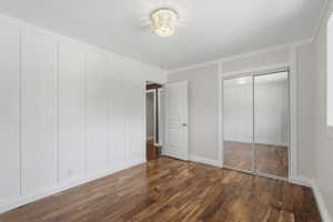 Bright room featuring wood-finish flooring, white paneling, and a mirrored sliding closet door