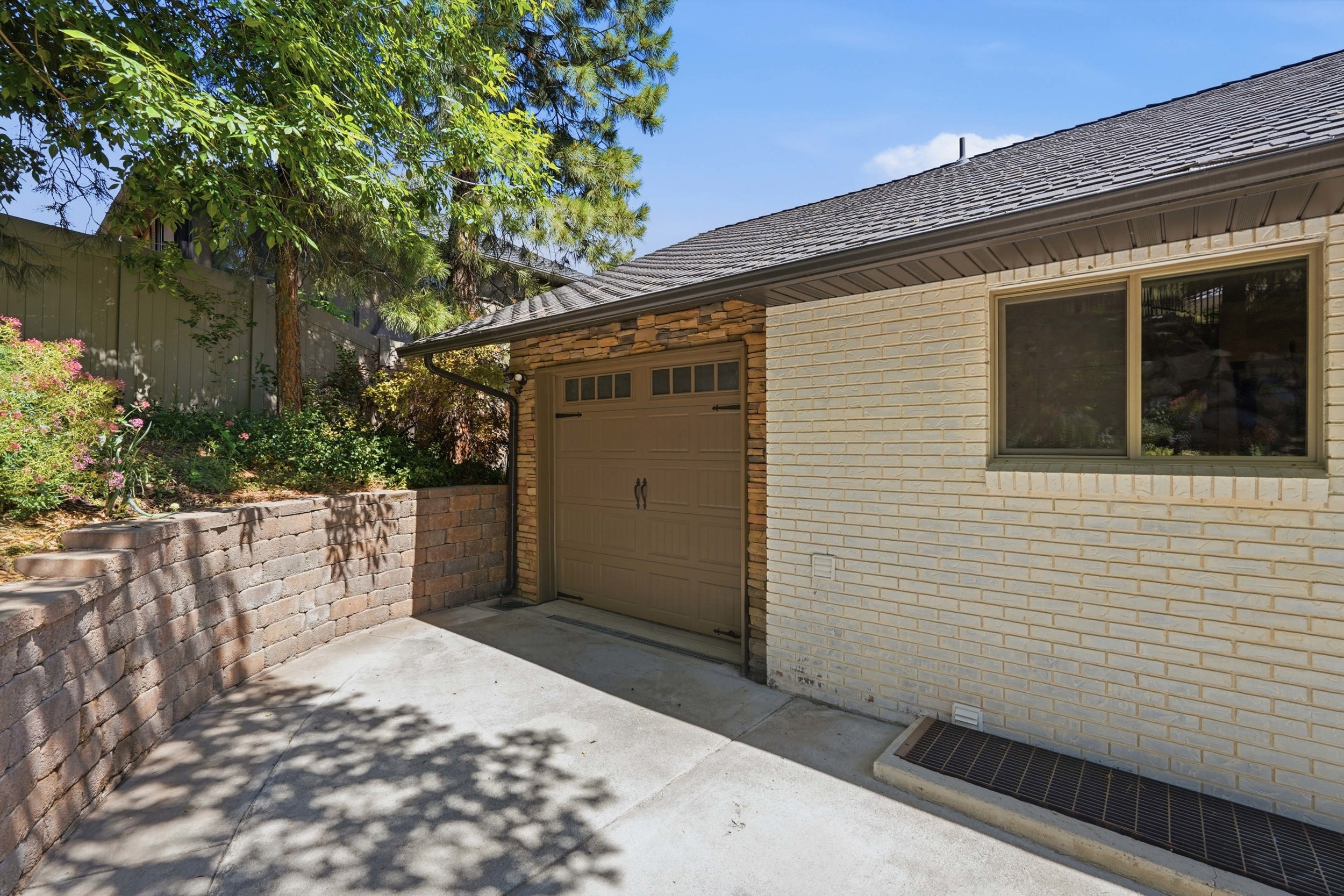Attached garage featuring a decorative overhead door and stone veneer detailing