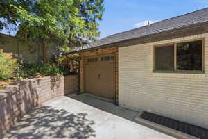 Attached garage featuring a decorative overhead door and stone veneer detailing