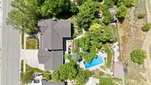 Expansive property featuring a multi-gabled main residence with a dark shingle roof, a spacious driveway, and mature landscaping