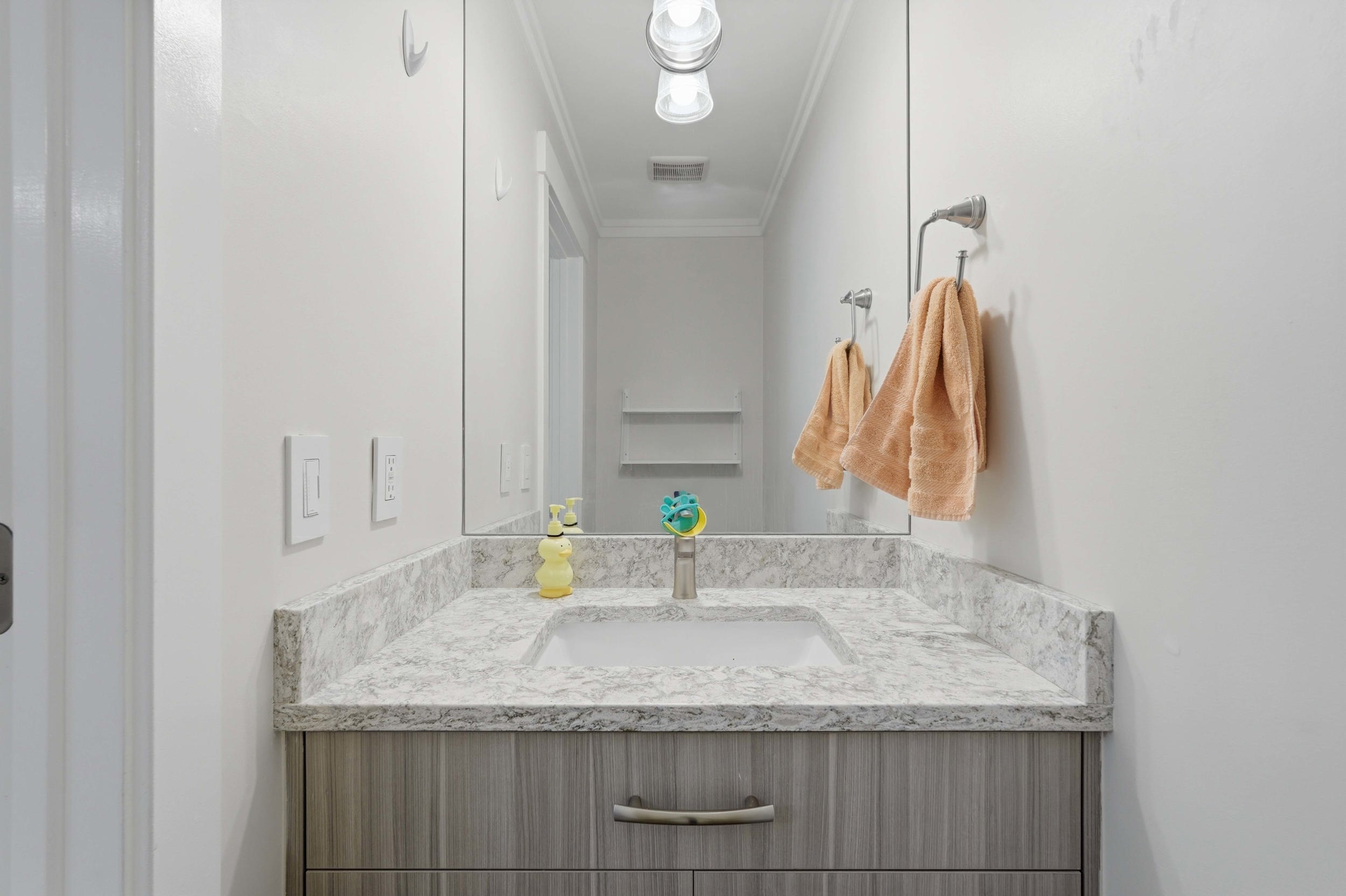 Modern vanity with a light wood-grain finish and brushed nickel hardware