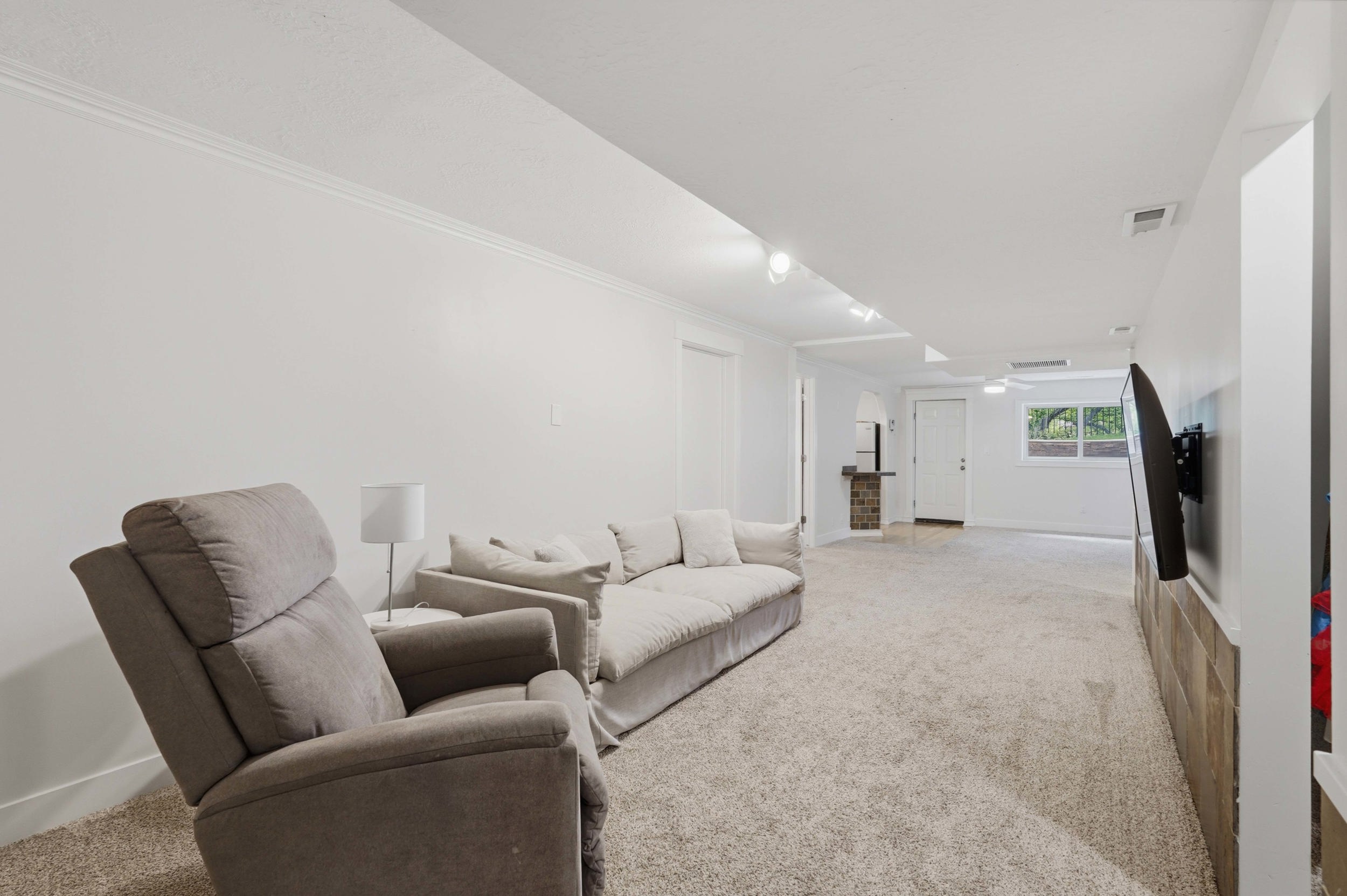 Spacious carpeted room featuring white walls and crown molding