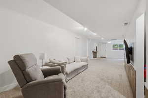 Spacious carpeted room featuring white walls and crown molding