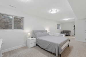 Carpeted room featuring a window with a stone-clad exterior wall, recessed lighting, and a neutral color palette