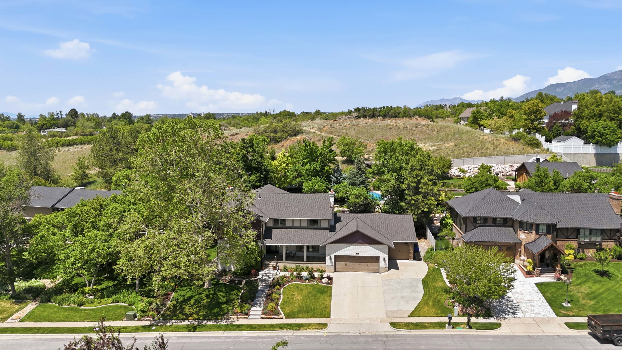 Contemporary two-story residence featuring a two-car garage, established landscaping, and a paved driveway