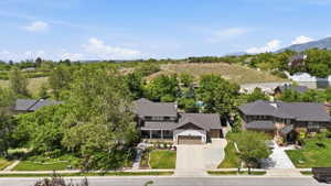 Contemporary two-story residence featuring a two-car garage, established landscaping, and a paved driveway