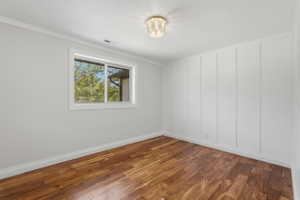 Warm wood-finish flooring complements the crisp white board and batten accent wall