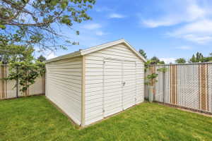 Exterior storage shed with horizontal siding, a gabled roof, and double doors