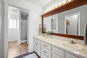 Primary Ensuite Double vanity with white cabinetry and integrated sinks, a wide framed mirror, and a frosted glass shower enclosure