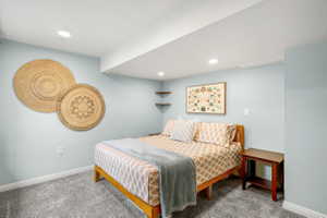 Carpeted room featuring light blue walls, white trim, and recessed ceiling lighting