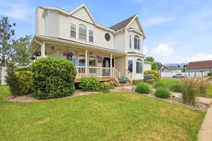 Two-story residence featuring white siding and a covered front porch with white railings