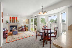 Open concept living area featuring a fireplace with a mantel, recessed lighting, and access to a patio through a sliding glass door