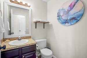 Bathroom featuring a dark wood vanity with an integrated sink, a speckled countertop, and a framed mirror