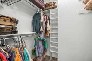 Interior closet featuring white walls, white shelving, and hanging rods