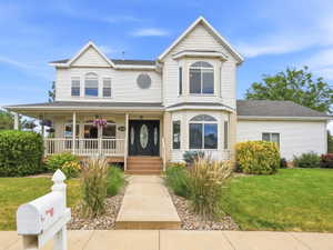 White siding exterior with a covered front porch featuring white railings